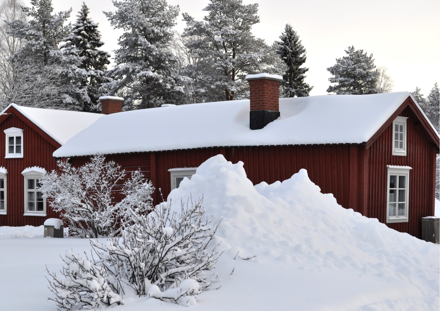 Röd bagarstuga bland snötäckta vidder på Hägnan